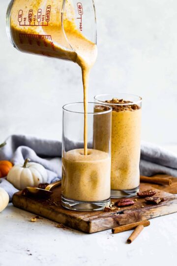 a pumpkin smoothie being poured into glasses