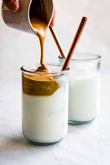 dalgona coffee being poured into a glass cup