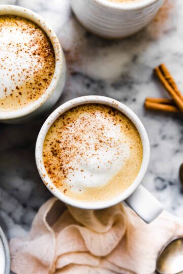 vegan pumpkin spice lattes in mugs with cinnamon and foam